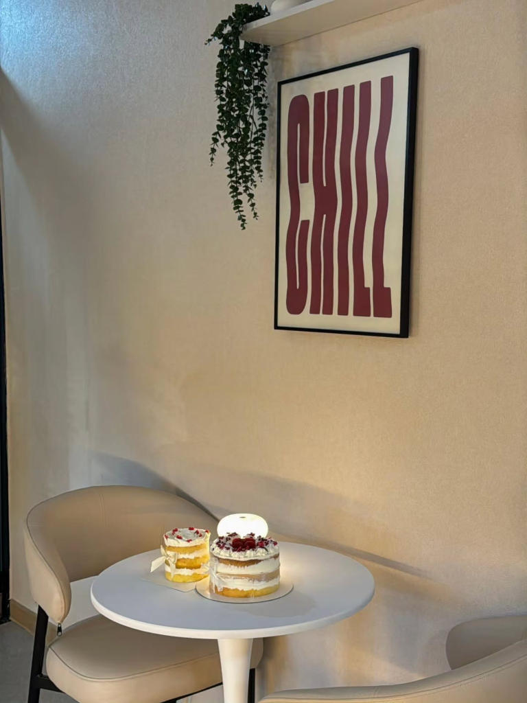 A cosy corner table at SweetByKim with a slice of layered cake